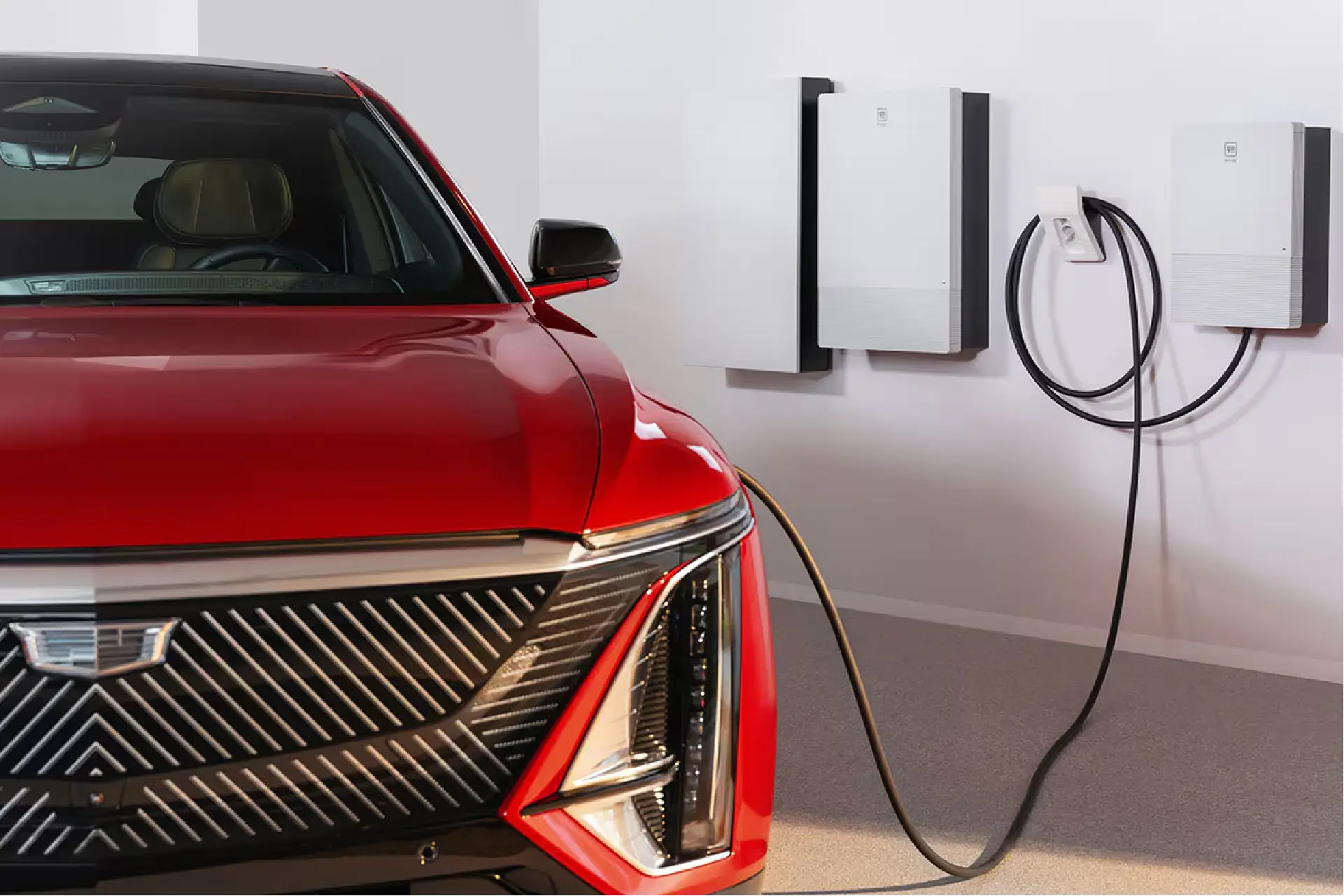 Residential electric vehicle charging station installation in Fort Wayne by licensed electrical contractor Home Enterprises Inc., showing a modern compact wall charger mounted next to a red car.